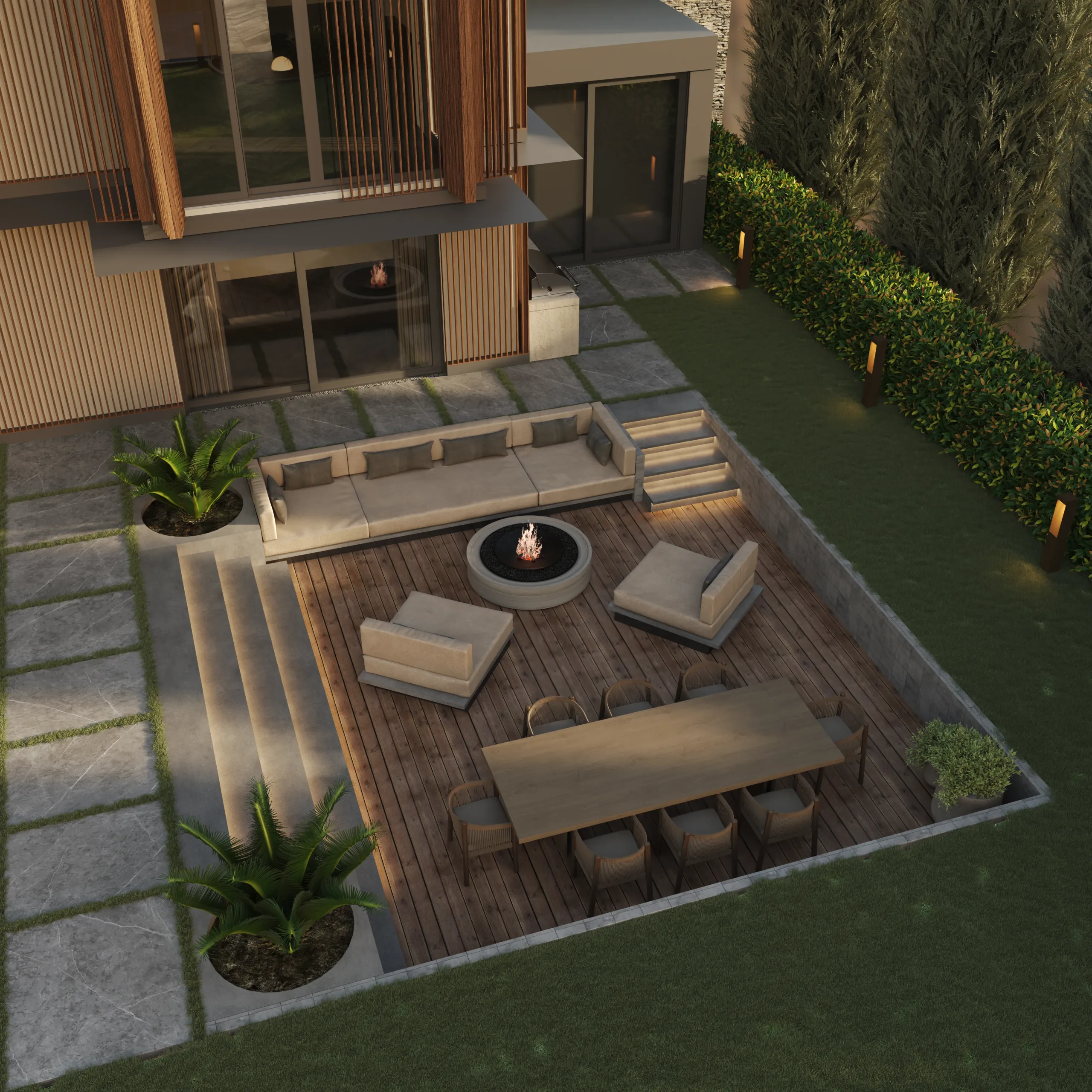 Aerial view of a sunken timber deck with a built-in fire pit, corner sofa and outdoor dining table.