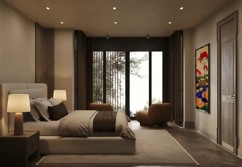 Attic master bedroom opening onto a garden through full-height glazing, with bouclé armchairs.
