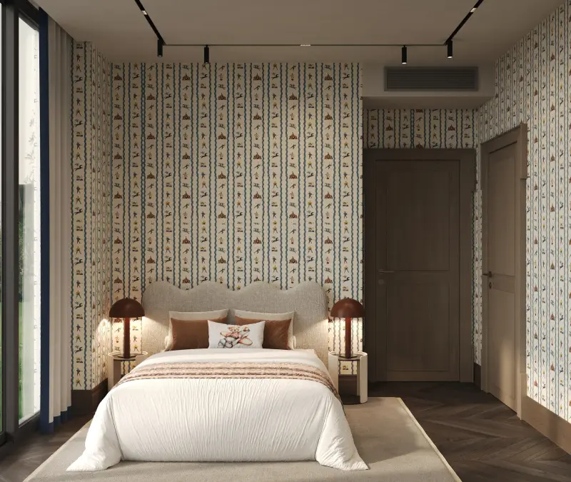 Guest bedroom wrapped in floral patterned wallpaper, with a scalloped headboard and red glass lamps.