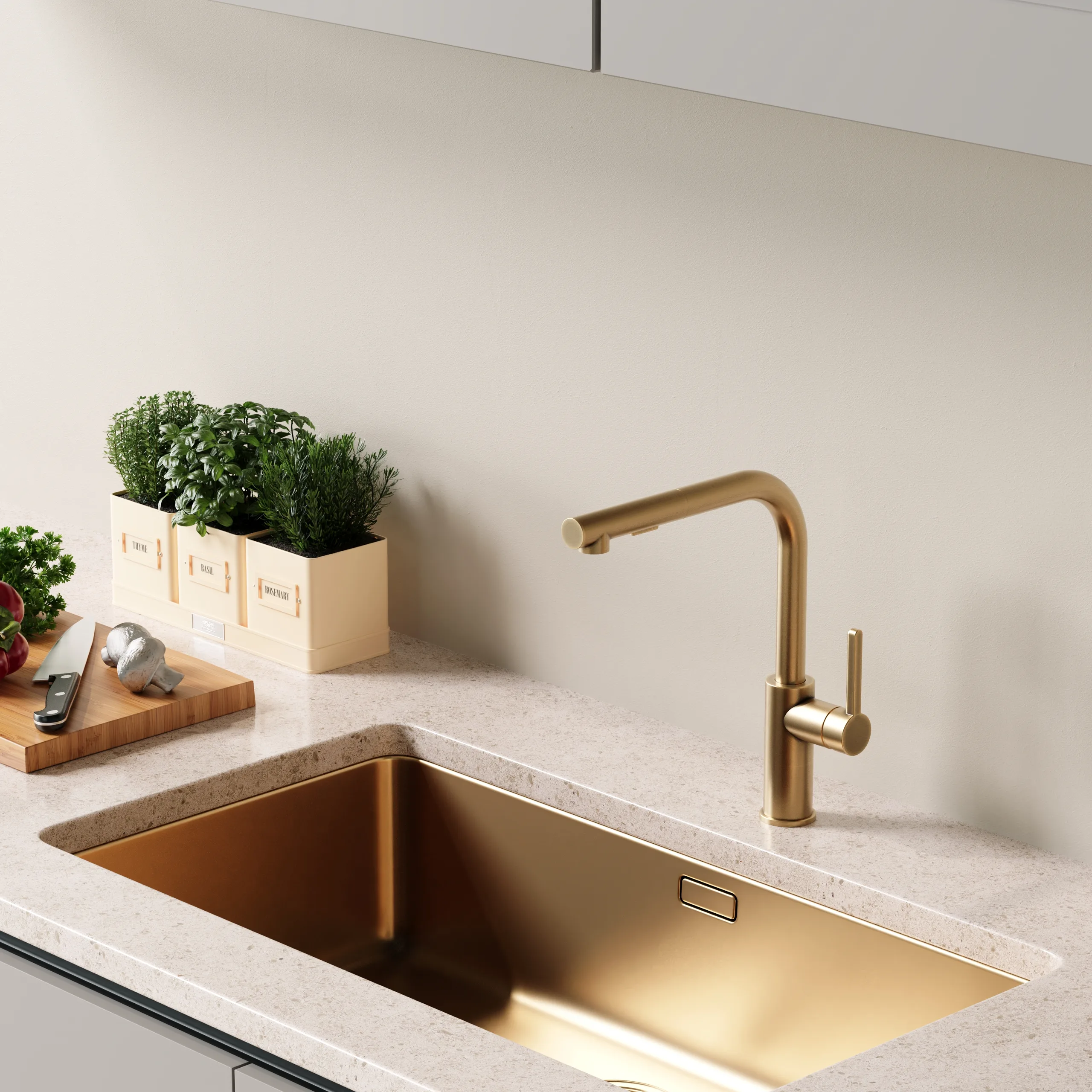 Brushed brass pull-out kitchen mixer above a matching gold undermount sink and a terrazzo worktop.